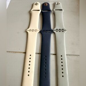Three Apple Watch Bands in Beige, Dark Blue, and Light Gray
